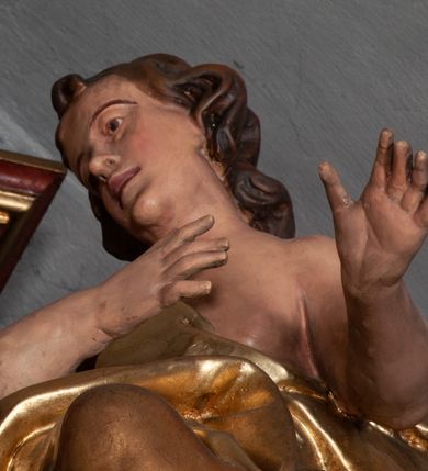 Zdjęcie nr 27: Retabulum jednokondygnacyjne, trójosiowe ze zwieńczeniem i bramkami. Mensa ołtarzowa z malowanym antepedium przedstawiającym scenę Ostatniej Wieczerzy według Leonarda da Vinci. Na mensie ustawione pozłacane tabernakulum w formie prostopadłościennej z częścią środkową w ozdobnej oprawie utworzonej przez dwa ukośnie dostawione filary ze spływami wolutowymi. Między nimi wypukłe w dolnej części drzwiczki dekorowane kielichem z hostią ponad kiśćmi winogron i między kłosami zbóż. Powyżej nisza konchowa wypełniona glorią, której koncha ozdobiona jest muszlą z rocaille’owym grzebieniem. Na wolutach osadzone adorujące krzyż putta. Część centralna nastawy flankowana kolumnami z głowicami jońskimi i ornamentem rokokowym. W polu w profilowanej złotej ramie przedstawienie koronacji Marii przez Trójcę Świętą. Drewniana konstrukcja skrzydeł bocznych tworzy ramę dla dwóch rzeźb ustawionych na bramkach, na odcinkach gzymsu rozszerzających się ku górze, które tworzą cokoły ozdobione w dolnej części rokokową muszlą. Po prawej stronie znajduje się rzeźba przedstawiająca św. Stanisława z Piotrowinem, po lewej św. Wojciecha. Obie rzeźby biskupów są tej samej wielkości, wypełniają prześwity w bocznych skrzydłach, w tle ozdobionych rocaille’owym ornamentem. Zewnętrzne płaszczyzny skrzydeł bocznych zdobi złota winorośl, a wewnętrzne ornament roślinny z motywem kwiatowym. Na kolumnach ustawionych na niewielkich cokołach wspiera się przełamane belkowanie zakończone gzymsem dźwigającym odcinkowy przyczółek z profilowaniem zakończonym wolutami. Na wysokości belkowania znajduje się płaskorzeźba przedstawiająca Boga Ojca i Ducha Świętego pod postacią gołębicy, wyłaniających się ze srebrnych obłoków; postacie otoczone są złotymi promieniami. Na bocznych osiach, analogicznie pojawiają się srebrne chmury o wolutowych kształtach, flankowane przez anielskie główki. Zwieńczenie rozszerza się ku górze i jest zamknięte łukiem nadwieszonym; znajduje się w nim obraz przedstawiający św. Floriana w profilowanej, złoconej wklęsło-wypukłej ramie. Całość zwieńczona kartuszem utworzonym z ornamentu rocaille’owego. Struktura polichromowana imitacją marmoryzacji w kolorze szarym i zielonym, fryzy i gzymsy bordowe i ciemnozielone, profile, ornamenty, kolumny złocone, dekoracje złocone i srebrzone. 