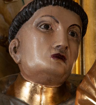 Zdjęcie nr 7: Rzeźba pełna na cokole. Święty Jacek wyobrażony w całej postaci, stojący frontalnie, w kontrapoście, z lewą nogą wysuniętą do przodu. Obie ręce zgięte w łokciach, w prawej trzyma kij, w lewej figurkę Matki Boskiej z Dzieciątkiem w srebrnych i złotych szatach. Twarz podłużna, oczy małe, nos prosty, usta szerokie, ciemnoczerwone. Głowa otoczona krótkimi, brązowymi włosami z wyciętą tonsurą. Święty ubrany jest w srebrny habit ze złotym szkaplerzem i czarny płaszcz z kapturem, spod ubrania widoczne czubki czarnych butów. Polichromia w odsłoniętych partiach karnacji traktowana naturalistyczne. 