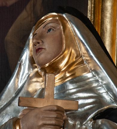 Zdjęcie nr 3: Rzeźba pełnoplastyczna, całopostaciowa, na cokole. Święta Katarzyna została ukazana frontalnie, w kontrapoście, z ciężarem na prawej nodze i głową przechyloną na prawo. Obie ręce krzyżuje na piersiach, w prawej trzyma krucyfiks, przez lewą ma przewieszony różaniec. Święta ma owalną twarz, ciemne spoglądające do góry oczy, wąskie brwi, prosty nos oraz wąskie, czerwone usta. Jest ubrana w srebrny habit dominikański, złoty szkaplerz oraz długi, czarny płaszcz, na głowie ma czarny welon. Polichromia w partiach ciała naturalistyczna.