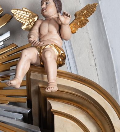 Zdjęcie nr 13: Ołtarz jednokondygnacyjny, jednoosiowy, na wysokim cokole, ze zwieńczeniem w formie glorii. Mensa ołtarzowa w kształcie prostopadłościanu, antepedium w postaci leżącego prostokąta, tkane, dekorowane rzędem maków w dolnej partii. Kondygnacja nastawy flankowana przez zwielokrotnione pilastry, ozdobione z zewnętrznych stron ornamentami roślinnymi i wysuniętymi przed nie kolumnami z głowicami kompozytowymi, ozdobionymi wolutami i liśćmi akantu. Kolumny i pilastry ustawione na wysokim cokole dekorowanym płycinami, dźwigają rozbudowane belkowanie, w pasie fryzu dekorowane rozetami. Belkowanie przełamuje się nad zwielokrotnionymi pilastrami i kolumnami i podtrzymuje fragment przerwanego przyczółka, na którym siedzą dwa putta. W polu znajduje się wnęka w kształcie stojącego prostokąta o górnych narożach wklęsłych, w której umieszczono krucyfiks. Zwieńczenie tworzy gloria promienista z centralnie umieszczonym okiem Opatrzności w otoku z obłoków i główek anielskich. Struktura polichromowana, marmoryzowana w odcieniu kremowym, kolumny, ornamenty i profile złocone, płyciny bordowe, gloria srebrzona i złocona.  