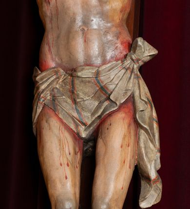 Zdjęcie nr 7: Ołtarz jednokondygnacyjny, jednoosiowy, na wysokim cokole, ze zwieńczeniem w formie glorii. Mensa ołtarzowa w kształcie prostopadłościanu, antepedium w postaci leżącego prostokąta, tkane, dekorowane rzędem maków w dolnej partii. Kondygnacja nastawy flankowana przez zwielokrotnione pilastry, ozdobione z zewnętrznych stron ornamentami roślinnymi i wysuniętymi przed nie kolumnami z głowicami kompozytowymi, ozdobionymi wolutami i liśćmi akantu. Kolumny i pilastry ustawione na wysokim cokole dekorowanym płycinami, dźwigają rozbudowane belkowanie, w pasie fryzu dekorowane rozetami. Belkowanie przełamuje się nad zwielokrotnionymi pilastrami i kolumnami i podtrzymuje fragment przerwanego przyczółka, na którym siedzą dwa putta. W polu znajduje się wnęka w kształcie stojącego prostokąta o górnych narożach wklęsłych, w której umieszczono krucyfiks. Zwieńczenie tworzy gloria promienista z centralnie umieszczonym okiem Opatrzności w otoku z obłoków i główek anielskich. Struktura polichromowana, marmoryzowana w odcieniu kremowym, kolumny, ornamenty i profile złocone, płyciny bordowe, gloria srebrzona i złocona.  