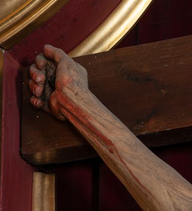 Zdjęcie nr 9: Ołtarz jednokondygnacyjny, jednoosiowy, na wysokim cokole, ze zwieńczeniem w formie glorii. Mensa ołtarzowa w kształcie prostopadłościanu, antepedium w postaci leżącego prostokąta, tkane, dekorowane rzędem maków w dolnej partii. Kondygnacja nastawy flankowana przez zwielokrotnione pilastry, ozdobione z zewnętrznych stron ornamentami roślinnymi i wysuniętymi przed nie kolumnami z głowicami kompozytowymi, ozdobionymi wolutami i liśćmi akantu. Kolumny i pilastry ustawione na wysokim cokole dekorowanym płycinami, dźwigają rozbudowane belkowanie, w pasie fryzu dekorowane rozetami. Belkowanie przełamuje się nad zwielokrotnionymi pilastrami i kolumnami i podtrzymuje fragment przerwanego przyczółka, na którym siedzą dwa putta. W polu znajduje się wnęka w kształcie stojącego prostokąta o górnych narożach wklęsłych, w której umieszczono krucyfiks. Zwieńczenie tworzy gloria promienista z centralnie umieszczonym okiem Opatrzności w otoku z obłoków i główek anielskich. Struktura polichromowana, marmoryzowana w odcieniu kremowym, kolumny, ornamenty i profile złocone, płyciny bordowe, gloria srebrzona i złocona.  