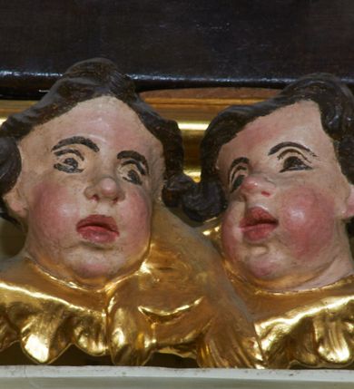 Zdjęcie nr 9: Ołtarz architektoniczny, drewniany, jednoosiowy, jednokondygnacyjny z bramkami. Mensa wąska, prostopadłościenna o ściankach wklęsło-wypukłych. Tabernakulum w kształcie prostopadłościennej skrzynki z przodu o linii wklęsło-wypukłej z uskokami. Ustawione jest na  wysokim cokole, flankowane parą szerokich, wklęsłych pilastrów, zdobionych ornamentem złożonym z przeplatających się wolut i kampanul. Ścianka frontowa wypukła, w polu prostokątne, metalowe drzwiczki, zdobione kiśćmi winogron i kłosami zbóż, pośrodku łaciński prosty krzyż. Całość zamknięta profilowanym gzymsem. Po bokach tabernakulum zwisy z kampanul, a na skrajach płaskorzeźbione uszy z liści akantu.  Do górnej krawędzi przybite gwoździem na trzech tulejach lampki oliwne. Nad tabernakulum tron wystawienia z rzeźbionymi w drewnie aniołkami na obłokach adorującymi krucyfiks. 

Retabulum ustawione na zdwojonym cokole, ujęte zwielokrotnionymi pilastrami toskańskimi i dwiema kolumnami kompozytowymi na wysokich cokołach, ustawionymi pod kątem i podtrzymującymi profilowane, przerwane belkowanie. Pilastry od strony wewnętrznej ołtarza są wklęsłe, ozdobione dwiema parami uskrzydlonych główek anielskich i zwisami z kwiatów; od zewnątrz pilastry mają trzony wypukłe.  W polu głównym wnęka, ujęta ramą w kształcie stojącego prostokąta o uszatych narożach. We wnęce na czerwonym tle umieszczony obraz Matki Boskiej Piekarskiej, na zasuwach obrazy „Koronacja Matki Boskiej” oraz „Św. Mikołaj”. Nad obrazem kartusz o kształcie zbliżonym do rombu z ornamentami rocaille&#039;owymi wokół; w polu napis „ALTARE / PRIVILEGI/ATUM”. Na osi kolumn, na przyczółku ustawione są wazony z kwiatami. 

Zwieńczenie w kształcie stojącego prostokąta, flankowane parą pilastrów podtrzymujących przerwane belkowanie, zamknięte gzymsem w formie łuku odcinkowego. Na szczycie promienista gloria z otokiem chmur pośrodku z płaskorzeźbionym monogramem IHS. W polu głównym obraz przedstawiający Ekstazę św. Teresy w kształcie stojącego prostokąta, zamknięty łukiem nadwieszonym. Po bokach zwieńczenia uszy z liści akantu i kwiatów. Pod obrazem uskrzydlona para główek aniołków. 

Bramki w formie stojącego prostokąta, flankowane węgarami, zamknięte wolutowym łukiem z ustawionymi na szczycie na niskich cokołach rzeźbami świętych: po lewej św. Piotra, a po prawej św. Pawła.  Przejście zamknięte łukiem wklęsło-wypukłym z uskokami. Struktura polichromowana w kolorze jasnobeżowym, ornamentyka złocona, detale srebrzone.
