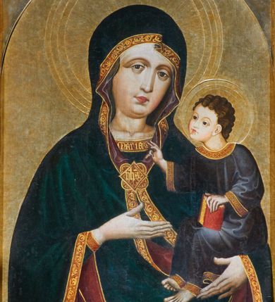 Zdjęcie nr 1: Obraz w kształcie stojącego prostokąta zamkniętego półkoliście. Matka Boska z Dzieciątkiem na ręku przedstawiona frontalnie w półpostaci, z głową lekko przechyloną na lewe ramię. Ręce ugięte w łokciach, lewą podtrzymuje Dzieciątko, wskazując na nie prawą dłonią. Twarz pełna, modelowana światłocieniowo, o dużych oczach, małych ustach i wydatnym podbródku. Cała postać Marii wraz z głową okryta maforionem ozdobionym na brzegach lamówką i spiętym na piersiach ozdobną klamrą z literami: ihs. Lamówka pierwotnie srebrzona i laserowana, ozdobiona malowaną wicią z motywów półpalmet.  Spod maforionu widoczne jedynie niewielkie fragmenty sukni ozdobione lamówką, przy dekolcie z minuskułowym napisem: maria, oraz chusta na głowie nieosłaniająca szyi. Dzieciątko siedzi na lewej ręce Marii, zwrócone w trzech czwartych w kierunku widza. Ręce ugięte w łokciach; prawą z palcami ułożonymi w geście błogosławieństwa kieruje w stronę Matki, lewą podtrzymuje kodeks, który opiera na lewym kolanie. Jezus ubrany jest w długą tunikę z długimi, szerokimi rękawami, ozdobioną przy brzegach ozdobną lamówką. Wokół głów koliste nimby z koncentrycznych okręgów. Tło złote.  