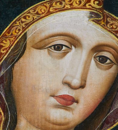 Zdjęcie nr 12: Obraz w kształcie stojącego prostokąta zamkniętego półkoliście. Matka Boska z Dzieciątkiem na ręku przedstawiona frontalnie w półpostaci, z głową lekko przechyloną na lewe ramię. Ręce ugięte w łokciach, lewą podtrzymuje Dzieciątko, wskazując na nie prawą dłonią. Twarz pełna, modelowana światłocieniowo, o dużych oczach, małych ustach i wydatnym podbródku. Cała postać Marii wraz z głową okryta maforionem ozdobionym na brzegach lamówką i spiętym na piersiach ozdobną klamrą z literami: ihs. Lamówka pierwotnie srebrzona i laserowana, ozdobiona malowaną wicią z motywów półpalmet.  Spod maforionu widoczne jedynie niewielkie fragmenty sukni ozdobione lamówką, przy dekolcie z minuskułowym napisem: maria, oraz chusta na głowie nieosłaniająca szyi. Dzieciątko siedzi na lewej ręce Marii, zwrócone w trzech czwartych w kierunku widza. Ręce ugięte w łokciach; prawą z palcami ułożonymi w geście błogosławieństwa kieruje w stronę Matki, lewą podtrzymuje kodeks, który opiera na lewym kolanie. Jezus ubrany jest w długą tunikę z długimi, szerokimi rękawami, ozdobioną przy brzegach ozdobną lamówką. Wokół głów koliste nimby z koncentrycznych okręgów. Tło złote.  