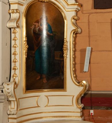 Zdjęcie nr 3: Obraz w kształcie stojącego prostokąta, zamkniętego łukiem półkolistym. W centrum kompozycji ukazany w całej postaci stojący św. Józef z Dzieciątkiem Jezus na rękach z prawej strony świętego, z głową skłonioną w Jego stronę. Święty ubrany jest w długą, niebieską suknię, brązowy płaszcz zarzucony na prawe ramię oraz sandały. Twarz szeroka, okolona siwą brodą, wysokie czoło, siwe włosy. Wokół głowy świętego złoty, kolisty nimb. Dzieciątko ukazane w pozycji leżącej, z lewego profilu, z lewą rączką wyciągniętą ku twarzy świętego, a prawą opadającą poniżej głowy, trzymającą kłosy zbóż i kiść winogrona. Dzieciątko półnagie, ułożone na białej pieluszce w rękach świętego Józefa. Całość ukazana we wnętrzu warsztatu stolarskiego, w którym ustawiony jest stół stolarski oraz narzędzia: piła, kątownik, hebel i toporek. Tło ciemne, ugrowe, przechodzące w ciemne brązy. Kolorystyka ciepła. Miękki modelunek światłocieniowy. Po prawej stronie obrazu słabo czytelna sygnatura „Teodor Stachowicz / malował 1868”. Rama drewniana, profilowana, złocona, w zwieńczeniu i po bokach zdobiona rzeźbionym ornamentem kwiatowym.
 