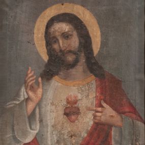 Zdjęcie nr 1: Obraz w kształcie stojącego prostokąta. W centrum kompozycji ukazany frontalnie Chrystus w półpostaci, z lewą ręką wskazującą na gorejące na piersi serce, prawą uniesioną w geście błogosławieństwa. Serce oplecione koroną cierniową. Twarz podłużna z długim i wąskim nosem, okolona krótkim zarostem oraz długimi włosami, z przedziałkiem pośrodku, spływającymi na ramiona i plecy. Wokół głowy złoty i kolisty nimb, a na dłoniach widoczne ślady męki. Chrystus ubrany w białą suknię z długimi, podwiniętymi rękawami i złotą lamówką u szyi oraz czerwony płaszcz, założony na plecy i przewieszony przez lewe ramię. Tło jednolite, szare. Kolorystyka przygaszona. Rama drewniana, profilowana, złocona, dekorowana ornamentem roślinnym.