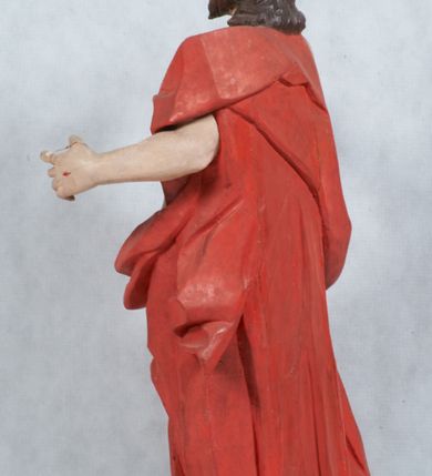 Zdjęcie nr 12: Rzeźba Chrystusa Zmartwychwstałego pełnoplastyczna, wolnostojąca, ustawiona na niskim cokole. Chrystus ukazany w całej postaci, ustawiony frontalnie, w delikatnym kontrapoście, ma prawą nogę ugiętą w kolanie i wspartą na czaszce z wężem. Ręce ma ugięte w łokciach i wyciągnięte przed siebie, w lewej trzyma chorągiew o długim drzewcu, a prawą unosi w geście błogosławieństwa. Jego twarz jest pociągła, o wysokim czole, długim i wąskim nosie, dużych oczach i rozchylonych ustach, okolona średniej długości, ciemną brodą i długimi, falowanymi włosami, które opadają na plecy i lewe ramię. Wokół głowy ma złoty nimb krzyżowy utworzony z wiązek promieni o nierównej długości. Chrystus ubrany jest w białe perizonium oraz czerwony płaszcz odsłaniający tors, otaczający figurę i przerzucony przez lewe ramię. Na dłoniach, stopach i boku zaznaczone są ślady męki. Polichromia ciała jest naturalistyczna, nimb pozłacany, drzewce chorągwi srebrzone.

