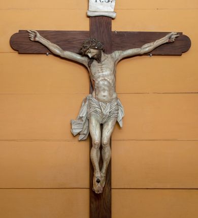Zdjęcie nr 1: Rzeźba Chrystusa przybita do krzyża trzema gwoździami, ukazana w typie Cristo morte. Ciało w delikatnym zwisie, o szeroko rozstawionych ramionach, sylwetka szczupła, choć muskularna. Chrystus ma głowę przechyloną na prawe ramię. Twarz szczupła, z wąskim i długim nosem, zamkniętymi oczami, na wpół otwartymi ustami, okolona krótką brodą. Włosy długie spływające na prawe ramię, na głowie korona cierniowa. Perizonium ciasno oplatające biodra, z jednym końcem dłuższym, zwisającym wzdłuż prawego uda. Z boku, dłoni, stóp i spod korony cierniowej spływają strużki krwi. Polichromia ciała naturalistyczna. Krzyż gładki, o ramionach zakończonych łukiem nadwieszonym; nad głową Chrystusa titulus w formie banderoli z napisem „J.N. / R.J.”
