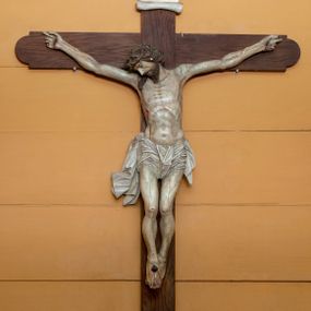 Zdjęcie nr 1: Rzeźba Chrystusa przybita do krzyża trzema gwoździami, ukazana w typie Cristo morte. Ciało w delikatnym zwisie, o szeroko rozstawionych ramionach, sylwetka szczupła, choć muskularna. Chrystus ma głowę przechyloną na prawe ramię. Twarz szczupła, z wąskim i długim nosem, zamkniętymi oczami, na wpół otwartymi ustami, okolona krótką brodą. Włosy długie spływające na prawe ramię, na głowie korona cierniowa. Perizonium ciasno oplatające biodra, z jednym końcem dłuższym, zwisającym wzdłuż prawego uda. Z boku, dłoni, stóp i spod korony cierniowej spływają strużki krwi. Polichromia ciała naturalistyczna. Krzyż gładki, o ramionach zakończonych łukiem nadwieszonym; nad głową Chrystusa titulus w formie banderoli z napisem „J.N. / R.J.”