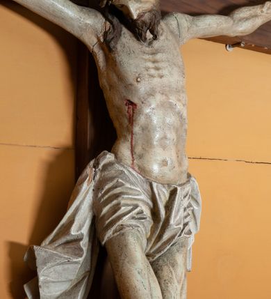 Zdjęcie nr 2: Rzeźba Chrystusa przybita do krzyża trzema gwoździami, ukazana w typie Cristo morte. Ciało w delikatnym zwisie, o szeroko rozstawionych ramionach, sylwetka szczupła, choć muskularna. Chrystus ma głowę przechyloną na prawe ramię. Twarz szczupła, z wąskim i długim nosem, zamkniętymi oczami, na wpół otwartymi ustami, okolona krótką brodą. Włosy długie spływające na prawe ramię, na głowie korona cierniowa. Perizonium ciasno oplatające biodra, z jednym końcem dłuższym, zwisającym wzdłuż prawego uda. Z boku, dłoni, stóp i spod korony cierniowej spływają strużki krwi. Polichromia ciała naturalistyczna. Krzyż gładki, o ramionach zakończonych łukiem nadwieszonym; nad głową Chrystusa titulus w formie banderoli z napisem „J.N. / R.J.”