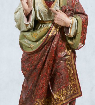 Zdjęcie nr 1: Rzeźba pełnoplastyczna, wolnostojąca, ustawiona na niskim prostopadłościennym cokole. Chrystus ukazany w całej postaci, stojący w delikatnym kontrapoście, prawą ręką czyni gest błogosławieństwa, lewą wskazuje na gorejące na piersi serce. Głowa delikatnie skłoniona w dół, twarz podłużna z długim i wąskim nosem, okolona krótką brodą, rozdzieloną na dwa pukle. Włosy długie, ciemnobrązowe, z przedziałkiem pośrodku, opadające na plecy. Chrystus ubrany jest w długą białą suknię, obszytą na brzegach złotą lamówką, przewiązaną w talii złotym paskiem oraz czerwony płaszcz o oliwkowozielonej podszewce, bogato zdobiony stylizowanymi kwiatami. Szaty dodatkowo dekorowane są szrafowaniem. Na dłoniach widoczne ślady męki, a na piersi gorejące serce, oplecione koroną cierniową, z zatkniętym u góry krzyżykiem, ukazane na tle promienistej glorii. Polichromia w odsłoniętych partiach ciała naturalistyczna. 