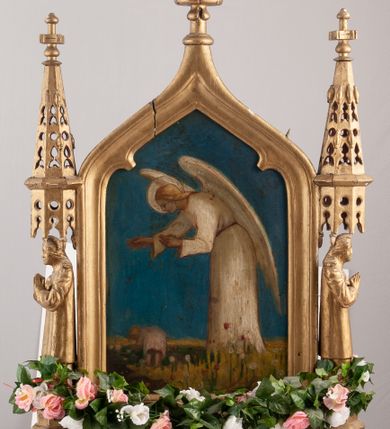 Zdjęcie nr 2: Feretron dwustronny z obrazami św. Stanisława Kostki oraz Anioła Stróża. Konstrukcja feretronu osadzona na dwóch nóżkach na planie koła, wspierających dwa wieloboczne w rzucie cokoły, połączone listwami stabilizującymi konstrukcję feretronu; cokoły zaopatrzone w otwory na drążki do noszenia. Na cokołach ustawione dwie rzeźby niezidentyfikowanych świętych, ujętych z profilu, nad nimi nadwieszone baldachimy zwieńczone stylizowanymi kwiatonami. W centrum tej konstrukcji obrazy ujęte w profilowaną ramę, zamkniętą łukiem ostrym o spłaszczonych ramionach, zwieńczoną krzyżykiem łacińskim o trójlistnie zakończonych ramionach. Struktura feretronu złocona. Na obrazie Anioł Stróż  ukazany jest po prawej stronie kompozycji, w postawie stojącej, widoczny z lewego profilu, pochylony nad dzieckiem bawiącym się na kwietnej łące. Ubrany jest w białą, długą sukienkę. Tło obrazu jednolite, ciemnoniebieskie. Po drugiej stronie feretronu znajduje się wizerunek św. Stanisława Kostki. Święty ukazany do kolan, stojący frontalnie, delikatnie zwrócony w lewo, z rękami złożonymi na piersi, z różańcem w dłoniach. Twarz szeroka, ze wzrokiem skierowanym ku górze, włosy krótkie i jasnobrązowe. Święty ubrany jest w sutannę jezuicką. Wokół głowy ma złoty, okrągły nimb. Tło obrazu jednolite, brązowe.
