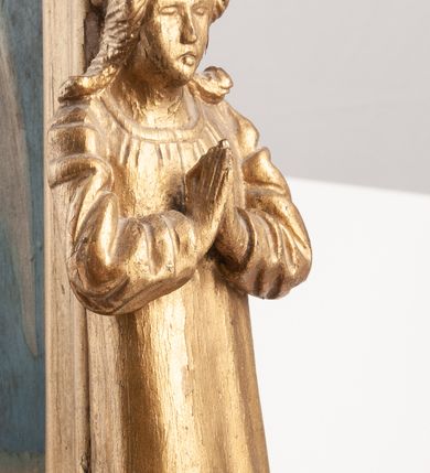 Zdjęcie nr 3: Feretron dwustronny z obrazami św. Stanisława Kostki oraz Anioła Stróża. Konstrukcja feretronu osadzona na dwóch nóżkach na planie koła, wspierających dwa wieloboczne w rzucie cokoły, połączone listwami stabilizującymi konstrukcję feretronu; cokoły zaopatrzone w otwory na drążki do noszenia. Na cokołach ustawione dwie rzeźby niezidentyfikowanych świętych, ujętych z profilu, nad nimi nadwieszone baldachimy zwieńczone stylizowanymi kwiatonami. W centrum tej konstrukcji obrazy ujęte w profilowaną ramę, zamkniętą łukiem ostrym o spłaszczonych ramionach, zwieńczoną krzyżykiem łacińskim o trójlistnie zakończonych ramionach. Struktura feretronu złocona. Na obrazie Anioł Stróż  ukazany jest po prawej stronie kompozycji, w postawie stojącej, widoczny z lewego profilu, pochylony nad dzieckiem bawiącym się na kwietnej łące. Ubrany jest w białą, długą sukienkę. Tło obrazu jednolite, ciemnoniebieskie. Po drugiej stronie feretronu znajduje się wizerunek św. Stanisława Kostki. Święty ukazany do kolan, stojący frontalnie, delikatnie zwrócony w lewo, z rękami złożonymi na piersi, z różańcem w dłoniach. Twarz szeroka, ze wzrokiem skierowanym ku górze, włosy krótkie i jasnobrązowe. Święty ubrany jest w sutannę jezuicką. Wokół głowy ma złoty, okrągły nimb. Tło obrazu jednolite, brązowe.
