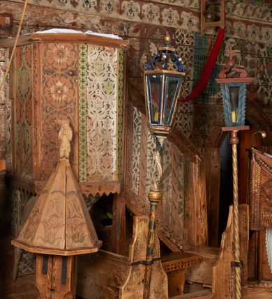 Zdjęcie nr 10: Kosz ambony na rzucie połowy ośmioboku, opięty prostymi listwami, dołem z wydzielonym cokołem z motywem ząbków, zwieńczony gzymsem. Kosz zawieszony na północnej ścianie prezbiterium na ostrosłupowej konsoli. Dostępny od wschodu, od strony wejścia do zakrystii, jednobiegowymi schodami z balustradą podzieloną listwami na romboidalne płyciny. Struktura zdobiona dekoracją patronową o motywach roślinno-geometrycznych.