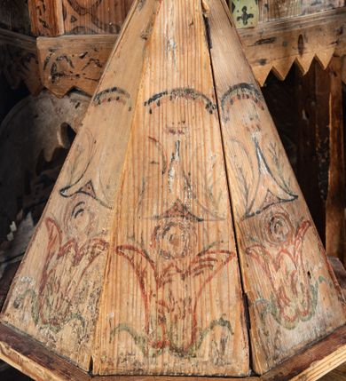 Zdjęcie nr 1: Chrzcielnica na Pokrywa w kształcie ostrosłupa o ośmiobocznej podstawie, zwieńczona ludową rzeźbą św. Jana Chrzciciela. Struktura pokrywy polichromowana motywami roślinno-geometrycznymi.