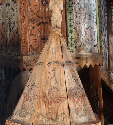 Zdjęcie nr 6: Chrzcielnica na Pokrywa w kształcie ostrosłupa o ośmiobocznej podstawie, zwieńczona ludową rzeźbą św. Jana Chrzciciela. Struktura pokrywy polichromowana motywami roślinno-geometrycznymi.