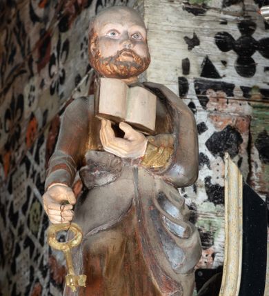 Zdjęcie nr 1: Rzeźba pełnoplastyczna, głęboko wydrążona, ustawiona na niewysokim cokole. Święty ukazany en face, w wykroku, lewą ręką podtrzymuje przy piersi otwartą księgę, w prawej, ugiętej lekko w łokciu i wyciągniętej przed siebie, trzyma klucz. Twarz pociągła, z wysokim czołem, o delikatnie rzeźbionych rysach, okolona zarostem. Ubrany w delikatnie drapowaną, złotą tunikę oraz srebrzony płaszcz zarzucony na lewe ramie i ujmujący postać po bokach spływami tkaniny.