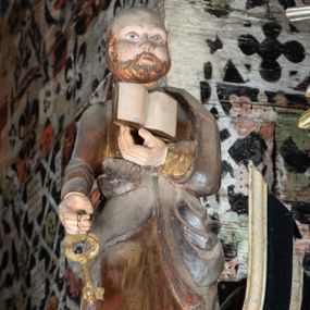 Zdjęcie nr 1: Rzeźba pełnoplastyczna, głęboko wydrążona, ustawiona na niewysokim cokole. Święty ukazany en face, w wykroku, lewą ręką podtrzymuje przy piersi otwartą księgę, w prawej, ugiętej lekko w łokciu i wyciągniętej przed siebie, trzyma klucz. Twarz pociągła, z wysokim czołem, o delikatnie rzeźbionych rysach, okolona zarostem. Ubrany w delikatnie drapowaną, złotą tunikę oraz srebrzony płaszcz zarzucony na lewe ramie i ujmujący postać po bokach spływami tkaniny.