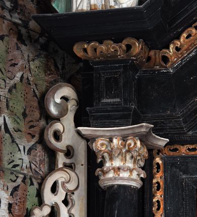 Zdjęcie nr 14: Nastawa ołtarzowa architektoniczna, jednoosiowa, jednokondygnacyjna, z wydzieloną predellą i zwieńczeniem, na cokole. Ołtarz kamienny z narzutem z tynku, sarkofagowy, wklęsło-wypukły. Mensa drewniana z portatylem z marmuru dębnickiego.Predella dekorowana płyciną w formie wydłużonego prostokąta z uszakami z malowanym przedstawieniem Bożego Narodzenia. Nastawa ujęta parą kolumn o kapitelach korynckich podtrzymujących pełne belkowanie belkowanie i gzyms, w części środkowej wyłamane ku górze trójbocznie. W polu środkowym nisza w formie stojącego prostokąta z uszakami, ujęta prostą ramą, wewnątrz gotycka szafa z figurą Matki Boskiej z Dzieciątkiem i czterech świętych dziewic. Na belkowaniu, w osi podpór figury św. Stanisława i św. Marcina (?). W zwieńczeniu ośmioboczny obraz z przedstawieniem Zwiastowania, w prostej ramie oraz bogatym obramieniu z ażurowych motywów ornamentu małżowinowo-chrząstkowego; u szczytu główka aniołka ze skrzydłami. Nastawa flankowana uszami utworzonymi z motywów ornamentu małżowinowo-chrząstkowego. W polu ponad niszą z obrazem rzeźbiona półpostać Boga Ojca. Gzyms u spodu dekorowany ornamentem małżowinowo-chrząstkowym. Struktura polichromowana na czarno, kapitele kolumn i część ornamentów srebrzone, pozostałe motywy ornamentalne złocone.