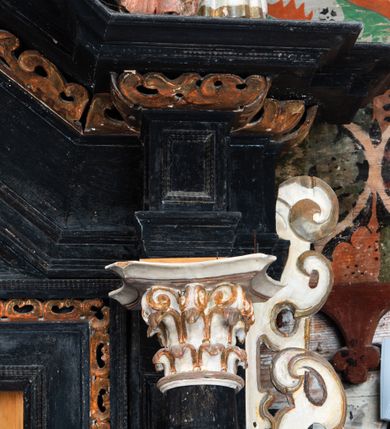 Zdjęcie nr 15: Nastawa ołtarzowa architektoniczna, jednoosiowa, jednokondygnacyjna, z wydzieloną predellą i zwieńczeniem, na cokole. Ołtarz kamienny z narzutem z tynku, sarkofagowy, wklęsło-wypukły. Mensa drewniana z portatylem z marmuru dębnickiego.Predella dekorowana płyciną w formie wydłużonego prostokąta z uszakami z malowanym przedstawieniem Bożego Narodzenia. Nastawa ujęta parą kolumn o kapitelach korynckich podtrzymujących pełne belkowanie belkowanie i gzyms, w części środkowej wyłamane ku górze trójbocznie. W polu środkowym nisza w formie stojącego prostokąta z uszakami, ujęta prostą ramą, wewnątrz gotycka szafa z figurą Matki Boskiej z Dzieciątkiem i czterech świętych dziewic. Na belkowaniu, w osi podpór figury św. Stanisława i św. Marcina (?). W zwieńczeniu ośmioboczny obraz z przedstawieniem Zwiastowania, w prostej ramie oraz bogatym obramieniu z ażurowych motywów ornamentu małżowinowo-chrząstkowego; u szczytu główka aniołka ze skrzydłami. Nastawa flankowana uszami utworzonymi z motywów ornamentu małżowinowo-chrząstkowego. W polu ponad niszą z obrazem rzeźbiona półpostać Boga Ojca. Gzyms u spodu dekorowany ornamentem małżowinowo-chrząstkowym. Struktura polichromowana na czarno, kapitele kolumn i część ornamentów srebrzone, pozostałe motywy ornamentalne złocone.