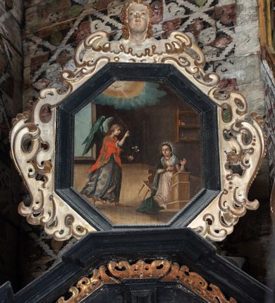 Zdjęcie nr 22: Nastawa ołtarzowa architektoniczna, jednoosiowa, jednokondygnacyjna, z wydzieloną predellą i zwieńczeniem, na cokole. Ołtarz kamienny z narzutem z tynku, sarkofagowy, wklęsło-wypukły. Mensa drewniana z portatylem z marmuru dębnickiego.Predella dekorowana płyciną w formie wydłużonego prostokąta z uszakami z malowanym przedstawieniem Bożego Narodzenia. Nastawa ujęta parą kolumn o kapitelach korynckich podtrzymujących pełne belkowanie belkowanie i gzyms, w części środkowej wyłamane ku górze trójbocznie. W polu środkowym nisza w formie stojącego prostokąta z uszakami, ujęta prostą ramą, wewnątrz gotycka szafa z figurą Matki Boskiej z Dzieciątkiem i czterech świętych dziewic. Na belkowaniu, w osi podpór figury św. Stanisława i św. Marcina (?). W zwieńczeniu ośmioboczny obraz z przedstawieniem Zwiastowania, w prostej ramie oraz bogatym obramieniu z ażurowych motywów ornamentu małżowinowo-chrząstkowego; u szczytu główka aniołka ze skrzydłami. Nastawa flankowana uszami utworzonymi z motywów ornamentu małżowinowo-chrząstkowego. W polu ponad niszą z obrazem rzeźbiona półpostać Boga Ojca. Gzyms u spodu dekorowany ornamentem małżowinowo-chrząstkowym. Struktura polichromowana na czarno, kapitele kolumn i część ornamentów srebrzone, pozostałe motywy ornamentalne złocone.