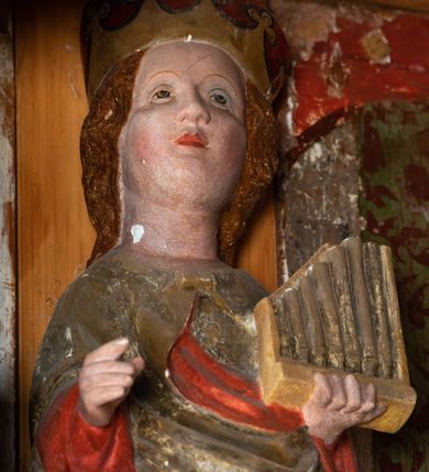 Zdjęcie nr 45: Nastawa ołtarzowa architektoniczna, jednoosiowa, jednokondygnacyjna, z wydzieloną predellą i zwieńczeniem, na cokole. Ołtarz kamienny z narzutem z tynku, sarkofagowy, wklęsło-wypukły. Mensa drewniana z portatylem z marmuru dębnickiego.Predella dekorowana płyciną w formie wydłużonego prostokąta z uszakami z malowanym przedstawieniem Bożego Narodzenia. Nastawa ujęta parą kolumn o kapitelach korynckich podtrzymujących pełne belkowanie belkowanie i gzyms, w części środkowej wyłamane ku górze trójbocznie. W polu środkowym nisza w formie stojącego prostokąta z uszakami, ujęta prostą ramą, wewnątrz gotycka szafa z figurą Matki Boskiej z Dzieciątkiem i czterech świętych dziewic. Na belkowaniu, w osi podpór figury św. Stanisława i św. Marcina (?). W zwieńczeniu ośmioboczny obraz z przedstawieniem Zwiastowania, w prostej ramie oraz bogatym obramieniu z ażurowych motywów ornamentu małżowinowo-chrząstkowego; u szczytu główka aniołka ze skrzydłami. Nastawa flankowana uszami utworzonymi z motywów ornamentu małżowinowo-chrząstkowego. W polu ponad niszą z obrazem rzeźbiona półpostać Boga Ojca. Gzyms u spodu dekorowany ornamentem małżowinowo-chrząstkowym. Struktura polichromowana na czarno, kapitele kolumn i część ornamentów srebrzone, pozostałe motywy ornamentalne złocone.