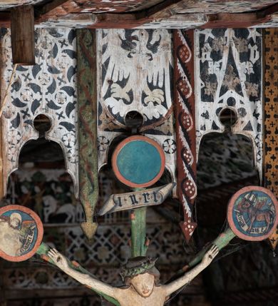 Zdjęcie nr 14: Polichromia pokrywa strop i ściany prezbiterium, strop, zaskrzynienia i ściany nawy oraz belkę tęczową, ambonę, ławkę kolatorską i parapet chóru muzycznego.  W dekoracji zastosowano 77 motywów zarówno figuralnych, jak i  heraldycznych, roślinnych, zwierzęcych, sakralnych, architektonicznych, tekstylnych, geometrycznych. Motywy tworzą oddzielne pasy dekoracyjne , dając wrażenie wzorzystych tkanin lub fryzów. Koloryt: jasna i ciemna czerwień, zielenie, błękity, brązy oraz żółcienie na białym lub czarnym podkładzie, czasem bezpośrednio na drewnie.  