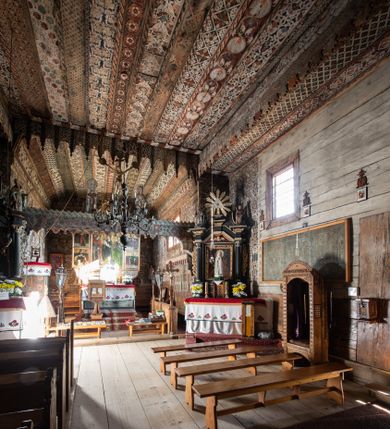 Zdjęcie nr 1: Polichromia pokrywa strop i ściany prezbiterium, strop, zaskrzynienia i ściany nawy oraz belkę tęczową, ambonę, ławkę kolatorską i parapet chóru muzycznego.  W dekoracji zastosowano 77 motywów zarówno figuralnych, jak i  heraldycznych, roślinnych, zwierzęcych, sakralnych, architektonicznych, tekstylnych, geometrycznych. Motywy tworzą oddzielne pasy dekoracyjne , dając wrażenie wzorzystych tkanin lub fryzów. Koloryt: jasna i ciemna czerwień, zielenie, błękity, brązy oraz żółcienie na białym lub czarnym podkładzie, czasem bezpośrednio na drewnie.  