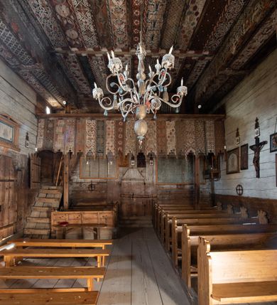 Zdjęcie nr 22: Polichromia pokrywa strop i ściany prezbiterium, strop, zaskrzynienia i ściany nawy oraz belkę tęczową, ambonę, ławkę kolatorską i parapet chóru muzycznego.  W dekoracji zastosowano 77 motywów zarówno figuralnych, jak i  heraldycznych, roślinnych, zwierzęcych, sakralnych, architektonicznych, tekstylnych, geometrycznych. Motywy tworzą oddzielne pasy dekoracyjne , dając wrażenie wzorzystych tkanin lub fryzów. Koloryt: jasna i ciemna czerwień, zielenie, błękity, brązy oraz żółcienie na białym lub czarnym podkładzie, czasem bezpośrednio na drewnie.  