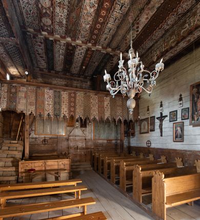 Zdjęcie nr 2: Polichromia pokrywa strop i ściany prezbiterium, strop, zaskrzynienia i ściany nawy oraz belkę tęczową, ambonę, ławkę kolatorską i parapet chóru muzycznego.  W dekoracji zastosowano 77 motywów zarówno figuralnych, jak i  heraldycznych, roślinnych, zwierzęcych, sakralnych, architektonicznych, tekstylnych, geometrycznych. Motywy tworzą oddzielne pasy dekoracyjne , dając wrażenie wzorzystych tkanin lub fryzów. Koloryt: jasna i ciemna czerwień, zielenie, błękity, brązy oraz żółcienie na białym lub czarnym podkładzie, czasem bezpośrednio na drewnie.  