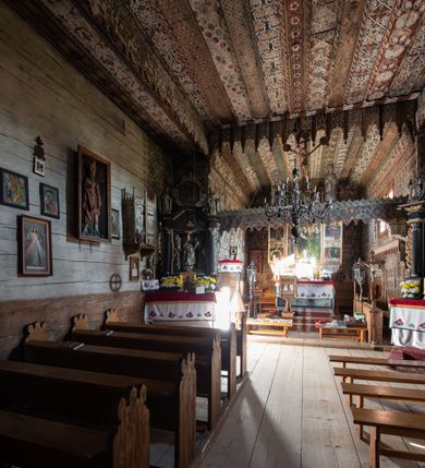 Zdjęcie nr 25: Polichromia pokrywa strop i ściany prezbiterium, strop, zaskrzynienia i ściany nawy oraz belkę tęczową, ambonę, ławkę kolatorską i parapet chóru muzycznego.  W dekoracji zastosowano 77 motywów zarówno figuralnych, jak i  heraldycznych, roślinnych, zwierzęcych, sakralnych, architektonicznych, tekstylnych, geometrycznych. Motywy tworzą oddzielne pasy dekoracyjne , dając wrażenie wzorzystych tkanin lub fryzów. Koloryt: jasna i ciemna czerwień, zielenie, błękity, brązy oraz żółcienie na białym lub czarnym podkładzie, czasem bezpośrednio na drewnie.  