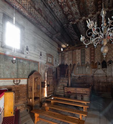 Zdjęcie nr 26: Polichromia pokrywa strop i ściany prezbiterium, strop, zaskrzynienia i ściany nawy oraz belkę tęczową, ambonę, ławkę kolatorską i parapet chóru muzycznego.  W dekoracji zastosowano 77 motywów zarówno figuralnych, jak i  heraldycznych, roślinnych, zwierzęcych, sakralnych, architektonicznych, tekstylnych, geometrycznych. Motywy tworzą oddzielne pasy dekoracyjne , dając wrażenie wzorzystych tkanin lub fryzów. Koloryt: jasna i ciemna czerwień, zielenie, błękity, brązy oraz żółcienie na białym lub czarnym podkładzie, czasem bezpośrednio na drewnie.  