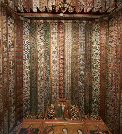 Zdjęcie nr 27: Polichromia pokrywa strop i ściany prezbiterium, strop, zaskrzynienia i ściany nawy oraz belkę tęczową, ambonę, ławkę kolatorską i parapet chóru muzycznego.  W dekoracji zastosowano 77 motywów zarówno figuralnych, jak i  heraldycznych, roślinnych, zwierzęcych, sakralnych, architektonicznych, tekstylnych, geometrycznych. Motywy tworzą oddzielne pasy dekoracyjne , dając wrażenie wzorzystych tkanin lub fryzów. Koloryt: jasna i ciemna czerwień, zielenie, błękity, brązy oraz żółcienie na białym lub czarnym podkładzie, czasem bezpośrednio na drewnie.  