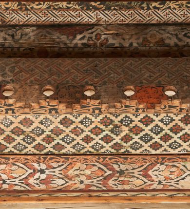 Zdjęcie nr 10: Polichromia pokrywa strop i ściany prezbiterium, strop, zaskrzynienia i ściany nawy oraz belkę tęczową, ambonę, ławkę kolatorską i parapet chóru muzycznego.  W dekoracji zastosowano 77 motywów zarówno figuralnych, jak i  heraldycznych, roślinnych, zwierzęcych, sakralnych, architektonicznych, tekstylnych, geometrycznych. Motywy tworzą oddzielne pasy dekoracyjne , dając wrażenie wzorzystych tkanin lub fryzów. Koloryt: jasna i ciemna czerwień, zielenie, błękity, brązy oraz żółcienie na białym lub czarnym podkładzie, czasem bezpośrednio na drewnie.  