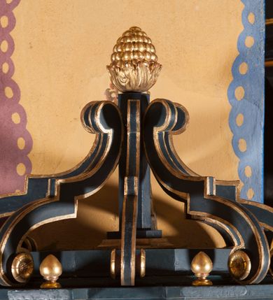 Zdjęcie nr 7: Ambona przyścienna, wisząca, z dostępem przez drzwi od strony zakrystii. Kosz wieloboczny, na cokole, z podwieszeniem w postaci ośmiu kabłąków, zakończonych szyszką. Ścianki kosza wydzielone kolumienkami podtrzymującymi wyłamane na ich osi belkowanie z silnie wysuniętym gzymsem tworzącym parapet. W polach nisze z płaskorzeźbionymi przedstawieniami ewangelistów. Po prawej stronie do kosza dobudowany ćwierćkolisty podest z pełną balustradą. Zaplecek wąski, ujęty dwiema kolumienkami stojącymi na wspornikach, podtrzymującymi imposty, na których stoją wazoniki. W dolnej części płycina. W polu obraz w formie stojącego prostokąta, ujęty ramą zakończoną muszlą, z przedstawieniem Chrystusa w typie Salvator Mundi. Baldachim na planie ośmioboku, w formie belkowania, na którym ustawione są kabłąki, podtrzymujące figurę anioła grającego na trąbie. Na podniebiu baldachimu figura gołębicy Ducha Świętego w glorii promienistej. Struktura polichromowana w kolorze niebiesko-zielonym; kolumienki, profile i ornamentyka złocone. 
