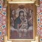 Zdjęcie nr 1: Obraz w formie stojącego prostokąta. W centrum pośród obłoków ukazana półpostać Matki Boskiej, zwróconej w trzech czwartych w lewo. Lewą ręką podtrzymuje Dzieciątko, razem z nim w prawej dłoni trzyma różaniec. Twarz ma owalną o łagodnych rysach, migdałowatych oczach, wąskim nosie i małych pełnych ustach. Wokół głowy nimb promienisty. Ubrana jest w jasnoczerwoną suknię oraz ciemnoniebieski maforion o wzorze roślinnym, z lamówką, zarzucony na głowę i ramiona. Wokół twarzy ma podwikę. Dzieciątko w pozycji siedzącej, zwrócone w trzech czwartych w prawo, prawą rękę unosi w geście błogosławieństwa, lewą trzyma z Matką różaniec. Twarz ma owalną, o pełnych policzkach, migdałowatych oczach, małym nosie i pełnych ustach, okoloną krótkimi włosami. Na głowie ma otwartą koronę. Ubrane jest w białą tunikę o roślinnym wzorze i czerwonej lamówce, przepasaną w talii. Postacie flankują dwa anioły zwrócone w trzech czwartych do wewnątrz, jedną ręką podtrzymujące nad głową Marii zamkniętą koronę, w drugiej trzymając gałązkę róży i lilii. Twarze mają okrągłe, o migdałowatych oczach skierowanych w górę, wąskich nosach i małych, pełnych ustach, okolone kręconymi włosami. Ubrane są w luźne tuniki, przepasane szarfami w talii. W dolnej części przedstawienia ukazane niewielkie postacie członków bractwa w dwóch grupach zwróconych do wewnątrz, klęczących, z rękami złożonymi w geście modlitwy. Pomiędzy nimi jedna klęcząca postać ukazana od tyłu z dwoma rękami uniesionymi do góry. Wszyscy członkowie bractwa ubrani są w czerwone tuniki z kapturami na głowach, w dłoniach trzymają różańce. Przedstawienie ukazane na tle brązowo-żółtego nieba rozświetlonego łuną w górnej części obrazu. 



