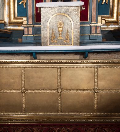 Zdjęcie nr 7: Nastawa architektoniczna, jednoosiowa z bramkami, jednokondygnacyjna ze zwieńczeniem, na wysokim cokole z wyłamanymi dwoma prostopadłościanami. Ołtarz skrzyniowy, prostopadłościenny, obity blachą; mensa drewniana. Na ołtarzu tabernakulum i tron wystawienia. Nastawa flankowana parą pilastrów i ustawioną przed nimi parą kolumn o kręconych trzonach oplecionych wicią roślinną, z korynckimi kapitelami. Podpory dźwigają pełne belkowanie wyłamane pod kątem na ich osi, z fryzem dekorowanym rozetami i wicią roślinną oraz cokoły z figurami puttów na obłokach. Niemal całe pole środkowe wypełnione wnęką w formie stojącego prostokąta o wciętych górnych narożach, ujętą profilowaną ramą. Wewnątrz dużo mniejszy obraz Matki Boskiej Gajowskiej w osobnej ramie, flankowany roślinnymi zwisami, od góry dekorowany uskrzydlonymi główkami anielskimi na obłokach. Nastawa ujęta uszami w kształcie roślinnych zwisów. Zwieńczenie w formie stojącego prostokąta, flankowane kolumienkami o kręconych trzonach oraz spływami wolutowymi. Podpory dźwigają pełne belkowanie wyłamane na ich osi, dekorowane rozetami i uskrzydloną główką anielską oraz fragmenty przerwanego półkolistego przyczółka. Na belkowaniu cokół z figurą anioła. Całe pole wypełnia wnęka w formie stojącego prostokąta ujętego ramą dekorowaną ornamentem roślinnym, z obrazem Matki Boskiej Anielskiej. Nastawę flankują bramki w profilowanych framugach, z przejściami w kształcie stojącego prostokąta zamkniętego łukiem półkolistym, w przyłuczach dekorowane ornamentem roślinnym. Zamknięte są cokołami utworzonymi ze spływów wolutowych, na których stoją figury św. Piotra i św. Pawła. Struktura polichromowana w kolorze niebiesko-zielonym, z czerwonymi detalami; kolumny, profile i ornamentyka złocone. 
