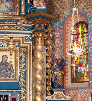 Zdjęcie nr 6: Nastawa architektoniczna, jednoosiowa z bramkami, jednokondygnacyjna ze zwieńczeniem, na wysokim cokole z wyłamanymi dwoma prostopadłościanami. Ołtarz skrzyniowy, prostopadłościenny, obity blachą; mensa drewniana. Na ołtarzu tabernakulum i tron wystawienia. Nastawa flankowana parą pilastrów i ustawioną przed nimi parą kolumn o kręconych trzonach oplecionych wicią roślinną, z korynckimi kapitelami. Podpory dźwigają pełne belkowanie wyłamane pod kątem na ich osi, z fryzem dekorowanym rozetami i wicią roślinną oraz cokoły z figurami puttów na obłokach. Niemal całe pole środkowe wypełnione wnęką w formie stojącego prostokąta o wciętych górnych narożach, ujętą profilowaną ramą. Wewnątrz dużo mniejszy obraz Matki Boskiej Gajowskiej w osobnej ramie, flankowany roślinnymi zwisami, od góry dekorowany uskrzydlonymi główkami anielskimi na obłokach. Nastawa ujęta uszami w kształcie roślinnych zwisów. Zwieńczenie w formie stojącego prostokąta, flankowane kolumienkami o kręconych trzonach oraz spływami wolutowymi. Podpory dźwigają pełne belkowanie wyłamane na ich osi, dekorowane rozetami i uskrzydloną główką anielską oraz fragmenty przerwanego półkolistego przyczółka. Na belkowaniu cokół z figurą anioła. Całe pole wypełnia wnęka w formie stojącego prostokąta ujętego ramą dekorowaną ornamentem roślinnym, z obrazem Matki Boskiej Anielskiej. Nastawę flankują bramki w profilowanych framugach, z przejściami w kształcie stojącego prostokąta zamkniętego łukiem półkolistym, w przyłuczach dekorowane ornamentem roślinnym. Zamknięte są cokołami utworzonymi ze spływów wolutowych, na których stoją figury św. Piotra i św. Pawła. Struktura polichromowana w kolorze niebiesko-zielonym, z czerwonymi detalami; kolumny, profile i ornamentyka złocone. 
