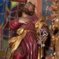 Zdjęcie nr 1: Pełnoplastyczna rzeźba ustawiona na nieregularnej podstawie. Święty ukazany frontalnie, w kontrapoście, z ugiętą prawą nogą oraz głową uniesioną i odchyloną do tyłu. Prawą rękę kładzie na piersi, w lewej nieco wyciągniętej przed siebie trzyma dwa skrzyżowane, srebrzone klucze. Twarz ma szczupłą, o oczach skierowanych w górę, dużym nosie i otwartych ustach, okoloną krótką brodą skręconą w dwa pukle oraz krótkimi, silnie kręconymi włosami. Ubrany jest w czerwoną tunikę, przepasaną w talii, silnie drapowaną, przylegającą do ciała oraz złocony płaszcz zawinięty na lewym ramieniu i zawiązany z przodu postaci, na stopach złocone buty. Polichromia ciała naturalistyczna. 

