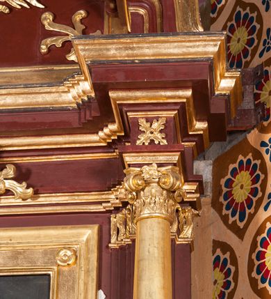 Zdjęcie nr 5: Nastawa architektoniczna, jednoosiowa, jednokondygnacyjna ze zwieńczeniem, ustawiona na dwustrefowym cokole z wyodrębnionymi dwoma prostopadłościanami. Ołtarz sarkofagowy, wybrzuszony w górnej części i zwężający się ku dołowi, na cokole; mensa drewniana. Na frontowej ścianie skrzyni ołtarzowej płycina w formie odwróconego trapezu dekorowana malowaną winną latoroślą na brązowo-zielonym tle. Na ołtarzu tabernakulum w formie drewnianej skrzynki, o ściętych narożach, ustawione na profilowanym cokole, zamknięte gzymsem. Ścianki dekorowane płycinami. Drzwiczki w formie stojącego prostokąta zamkniętego łukiem półkolistym nadwieszonym, z przedstawieniem kielicha z hostią. Nastawa ujęta parą kolumn dźwigających pełne belkowanie wyłamane na ich osi, z fryzem dekorowanym rozetami i kartuszem oraz fragmenty przerwanego półkolistego przyczółka z figurami puttów. Niemal całe pole środkowe wypełnione jest wnęką w formie stojącego prostokąta, ujętego grubą ramą dekorowaną rozetami, z obrazem Najświętszego Serca Jezusa. Zwieńczenie w formie zbliżonej do trapezu, o wklęsłych bokach, zamknięte wolutami i muszlą. W polu obraz Zwiastowania w formie stojącego owalu, ujęty profilowaną ramą, dekorowany naokoło ornamentem roślinnym. Struktura polichromowana w kolorze brązowo-czerwonym; kolumny, profile i ornamentyka złocone. 