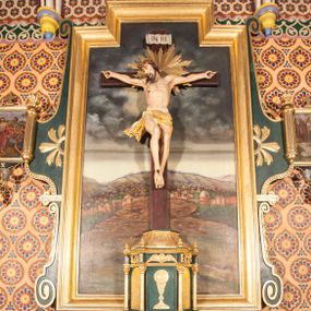 Zdjęcie nr 1: Nastawa niearchitektoniczna, ramowa, ustawiona na wysokim cokole. Ołtarz sarkofagowy, wybrzuszony w górnej części, zwężający się ku dołowi, na cokole; mensa drewniana. Na frontowej ścianie skrzyni ołtarzowej płycina w formie odwróconego trapezu dekorowana malowaną winną latoroślą na ciemnoczerwonym tle. Na ołtarzu ustawione tabernakulum w formie drewnianej skrzynki na planie połowy ośmioboku, wydzielone kolumienkami na cokołach, dźwigającymi pełne belkowanie o fryzie dekorowanym uskrzydloną główką anielską i ornamentem roślinnym. Na ściankach płyciny w kształcie stojącego prostokąta zamkniętego łukiem półkolistym wypełnione rytym ornamentem roślinnym. Drzwiczki o tej samej formie z rytym przedstawieniem kielicha z hostią w glorii. Tabernakulum zwieńczone tronem wystawienia w kształcie wklęsło-wypukłego cokołu, zwężającego się ku górze. Nastawa w formie stojącego prostokąta o wciętych górnych narożach, ujęta profilowaną ramą, z uszakami w formie spływów wolutowych z wyodrębnionymi zwojami dekorowanymi ornamentem roślinnym; zwieńczona rocaille'owym kartuszem. W polu figura Chrystusa Ukrzyżowanego przybita do prostego krzyża, ukazanego na tle malowanej panoramy Jerozolimy, w której prawym dolnym roku znajduje się sygnatura „S(tanisław) Karas / 1913”. 



