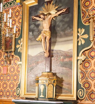 Zdjęcie nr 3: Nastawa niearchitektoniczna, ramowa, ustawiona na wysokim cokole. Ołtarz sarkofagowy, wybrzuszony w górnej części, zwężający się ku dołowi, na cokole; mensa drewniana. Na frontowej ścianie skrzyni ołtarzowej płycina w formie odwróconego trapezu dekorowana malowaną winną latoroślą na ciemnoczerwonym tle. Na ołtarzu ustawione tabernakulum w formie drewnianej skrzynki na planie połowy ośmioboku, wydzielone kolumienkami na cokołach, dźwigającymi pełne belkowanie o fryzie dekorowanym uskrzydloną główką anielską i ornamentem roślinnym. Na ściankach płyciny w kształcie stojącego prostokąta zamkniętego łukiem półkolistym wypełnione rytym ornamentem roślinnym. Drzwiczki o tej samej formie z rytym przedstawieniem kielicha z hostią w glorii. Tabernakulum zwieńczone tronem wystawienia w kształcie wklęsło-wypukłego cokołu, zwężającego się ku górze. Nastawa w formie stojącego prostokąta o wciętych górnych narożach, ujęta profilowaną ramą, z uszakami w formie spływów wolutowych z wyodrębnionymi zwojami dekorowanymi ornamentem roślinnym; zwieńczona rocaille&#039;owym kartuszem. W polu figura Chrystusa Ukrzyżowanego przybita do prostego krzyża, ukazanego na tle malowanej panoramy Jerozolimy, w której prawym dolnym roku znajduje się sygnatura „S(tanisław) Karas / 1913”. 



