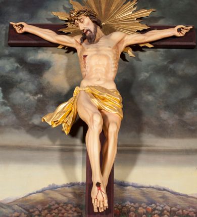 Zdjęcie nr 1: Figura Chrystusa umarłego przybita jest trzema gwoździami do krzyża o prostych ramionach. Ciało w lekkim zwisie o horyzontalnie rozłożonych ramionach, z głową opadającą na prawy bark, nogi silnie ugięte w kolanach, stopy skrzyżowane w układzie prawa na lewą. Chrystus ma podłużną twarz, o migdałowatych, zamkniętych oczach, dużym, garbatym nosie oraz szerokich, rozchylonych ustach, okoloną krótką brodą oraz skręconymi w pukle włosami opadającymi na prawe ramię. Na głowie ma nałożoną koronę cierniową. Ciało ma silnie wychudzone z wyraźnie podkreślonymi guzowatymi żebrami, mostkiem i kośćmi biodrowymi, z silnie wciętą talią oraz zapadłą płaszczyzną brzucha. Nogi i ręce o podkreślonej wklęsło-wypukłej linii mięśni i ścięgien. Złocone perizonium zawieszone na podwójnym sznurze, odsłaniające prawe udo, z rozwianym zwisem tkaniny na prawym boku. Na krzyżowaniu belek krzyża, na tle głowy Zbawiciela gloria promienista. Na zakończeniu pionowej belki krzyża banderola z napisem „IN RI”. Polichromia ciała Chrystusa naturalistyczna, z zaznaczonymi śladami męki. 


