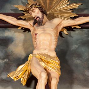 Zdjęcie nr 1: Figura Chrystusa umarłego przybita jest trzema gwoździami do krzyża o prostych ramionach. Ciało w lekkim zwisie o horyzontalnie rozłożonych ramionach, z głową opadającą na prawy bark, nogi silnie ugięte w kolanach, stopy skrzyżowane w układzie prawa na lewą. Chrystus ma podłużną twarz, o migdałowatych, zamkniętych oczach, dużym, garbatym nosie oraz szerokich, rozchylonych ustach, okoloną krótką brodą oraz skręconymi w pukle włosami opadającymi na prawe ramię. Na głowie ma nałożoną koronę cierniową. Ciało ma silnie wychudzone z wyraźnie podkreślonymi guzowatymi żebrami, mostkiem i kośćmi biodrowymi, z silnie wciętą talią oraz zapadłą płaszczyzną brzucha. Nogi i ręce o podkreślonej wklęsło-wypukłej linii mięśni i ścięgien. Złocone perizonium zawieszone na podwójnym sznurze, odsłaniające prawe udo, z rozwianym zwisem tkaniny na prawym boku. Na krzyżowaniu belek krzyża, na tle głowy Zbawiciela gloria promienista. Na zakończeniu pionowej belki krzyża banderola z napisem „IN RI”. Polichromia ciała Chrystusa naturalistyczna, z zaznaczonymi śladami męki. 


