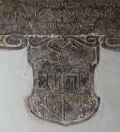 Zdjęcie nr 3: Epitafium w formie leżącego prostokąta, ujęte ramą utworzoną ze zwróconych ku sobie par wolut. U spodu tablicy herb z labrami, zwieńczony klejnotem w postaci hełmu w koronie i zbrojnej nogi, o czteropolowej tarczy z herbami: Nowina, Topór, Kietlicz, Doliwa. Epitafium zwieńczone rytowanym medalionem z przedstawieniem czaszki, skrzyżowanych piszczeli i klepsydry, ujętym ornamentem roślinnym przechodzącym w woluty, zakończonym krzyżem. W polu inskrypcja „D(EO) O(PTIMO) M(AXIMO) / G(E)N(ER)OSO OLIM IACOBO DE WILKOWICE WIEYSKI / HEREDI IN FAŁKOWICE / SPECTATAE VIRTVTIS ET PROBITATIS VIRO / IN CLERVM IN PAVPERES IN ECCLESIAM HANC / CVI MILLE FLOREN(ORUM) IN CENSVM DONAVIT / PIA LIBERALITATE BENEFICO / CHRISTIANO OBITV AD IMMORTALEM VITAM TRANSLATO / MAESTISSIMA CONIVNX RELICTA CHATARINA DE POREMBA / MONVMENTVM HOC POSVIT/ OBIIT ANNO D(OMI)NI 1673 MENSE FEBRVARY DIE 22 / AETATIS SVAE 49.”