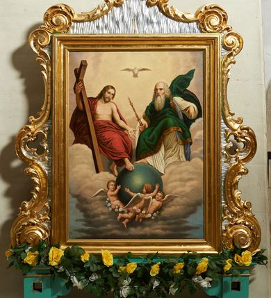 Zdjęcie nr 1: Feretron w formie stojącego prostokąta, w profilowanej ramie, ujęty spływami wolutowymi, zakończony szczytem, dekorowany rocaille&#039;m, pola zdobione falistymi żłobkami. Rama ustawiona na listwie i dwóch cokołach, o profilowanych brzegach, z otworami na drążki. 
Na awersie obraz z Matką Boską Różańcową oraz św. Dominikiem i św. Katarzyną Sieneńską w formie stojącego prostokąta. Matka Boska w centrum kompozycji ukazana jako siedząca na tronie, na wysokim postumencie, z Dzieciątkiem na lewym kolanie. Maria przedstawiona frontalnie, przechylona w prawo, prawą ręką podaje różaniec św. Dominikowi, lewą przytrzymuje Dzieciątko. Ubrana jest w czerwoną suknię i niebieski płaszcz z fioletową podszewką, okalający głowę, spięty pod szyją, opadający na ramiona i kolana. Dzieciątko zwrócone w trzech czwartych w prawo, z tułowiem i głową skręconą w drugą stronę, lekko pochylone podaje oburącz różaniec św. Katarzynie. Ubrane jest w białą tunikę przepasaną w talii. W lewym dolnym rogu postać klęczącego św. Dominika, zwróconego profilem w stronę Matki Boskiej, z wyciągniętymi w górę rękami, w których trzyma różaniec, z uniesioną głową. Święty ubrany jest w biały habit i czarny płaszcz, na głowie ma tonsurę. W prawym dolnym rogu obrazu postać klęczącej św. Katarzyny Sieneńskiej, zwróconej profilem ku Marii, z pochyloną głową, w prawej uniesionej ręce trzyma różaniec, w lewej gałązkę lilii. Ubrana jest w biały habit i czarny płaszcz, na głowie ma czarny welon i koronę cierniową. Pomiędzy świętymi, na cokole wieniec z czerwonych róż i leżąca biała lilia. U nóg św. Dominika otwarta księga. Scenę ukazana na tle błękitno-różowego nieba z obłokami. Tron ujęty dwoma aniołkami i czterema uskrzydlonymi główkami anielskimi. 
Na rewersie obraz z przedstawieniem Trójcy Świętej w formie stojącego prostokąta. Trójca ukazana jako tronującą w niebie, zasiadająca ponad globem podtrzymywanym przez trzy putta. Po prawej stronie siedząca postać Chrystusa, zwróconego w trzech czwartych w lewo, z wyciągniętą prawą nogą, spoczywającą na globie. Prawą ręką przytrzymuje na ramieniu krzyż, lewą wyciąga przed siebie. Twarz ma pociągłą, o dużych oczach i prostym nosie, okoloną jasną, gęstą brodą i jasnobrązowymi włosami, opadającymi na ramiona. Jezus ubrany jest w czerwony płaszcz, zarzucony na ramiona, biodra i nogi, odsłaniający tors. Na jego ciele widoczne są ślady męki. Po lewej siedząca postać Boga Ojca zwróconego w trzech czwartych w prawo, z prawą stopą opartą na globie. W prawej dłoni wspartej na kolanie trzyma berło, lewa jest ugięta i uniesiona. Twarz ma pociągłą, z wysokim czołem, o starczych rysach, dużych oczach i garbatym nosie, okoloną długą siwą brodą opadającą na pierś oraz siwymi włosami sięgającymi ramion. Ubrany jest w długą, białą tunikę oraz zielony płaszcz spięty na lewym ramieniu, o niebieskiej podszewce i złoconej lamówce. Nad postaciami unosi się gołębica Ducha Świętego. Scena na tle szaro-błękitnych, skłębionych chmur, w górnej części obrazu rozświetlone niebo. 


