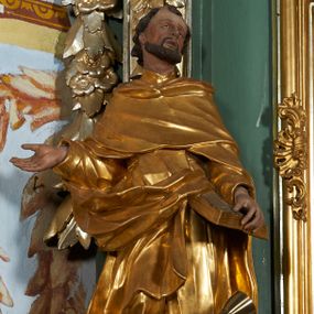 Zdjęcie nr 1: Rzeźba drążona z tyłu, ukazana frontalnie z głową skierowaną w prawo, w kontrapoście, o esowato wygiętej sylwetce. Lewa ręka świętego podtrzymuje księgę opartą na biodrze, prawa jest zgięta i uniesiona w bok. Twarz pociągła, o długim nosie, półprzymkniętych oczach zwróconych ku górze. Okolona jest krótką brodą oraz włosami z tonsurą na czubku głowy. Święty ubrany jest w habit oraz płaszcz zawinięty na prawej nodze. Habit o delikatnych załamaniach tkaniny, ściśle przylegający do ciała. Płaszcz głęboko rzeźbiony, silnie marszczony o grubych, ostrych fałdach. Polichromia naturalistyczna w partiach ciała, szaty złocone, atrybuty srebrzone.