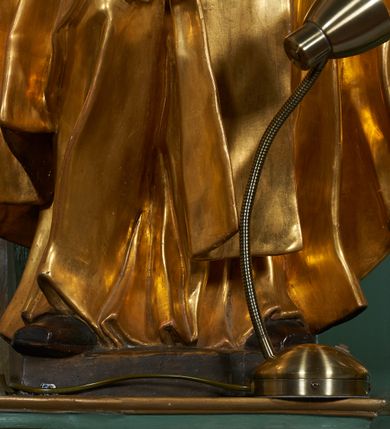 Zdjęcie nr 8: Rzeźba drążona z tyłu, ukazana frontalnie z głową skierowaną w prawo, w kontrapoście, o esowato wygiętej sylwetce. Lewa ręka świętego podtrzymuje księgę opartą na biodrze, prawa jest zgięta i uniesiona w bok. Twarz pociągła, o długim nosie, półprzymkniętych oczach zwróconych ku górze. Okolona jest krótką brodą oraz włosami z tonsurą na czubku głowy. Święty ubrany jest w habit oraz płaszcz zawinięty na prawej nodze. Habit o delikatnych załamaniach tkaniny, ściśle przylegający do ciała. Płaszcz głęboko rzeźbiony, silnie marszczony o grubych, ostrych fałdach. Polichromia naturalistyczna w partiach ciała, szaty złocone, atrybuty srebrzone.