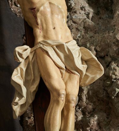 Zdjęcie nr 5: Krzyż zwrócony jest w trzech czwartych w lewo, lekko pochylony, na górnej belce krzyża zwój z napisem „I.N / R.I.”. Do niego przybita jest trzema gwoździami pełnoplastyczna rzeźba umarłego Chrystusa. Figura w delikatnym zwisie ciała o szeroko rozłożonych ramionach oraz łukowato wygiętej sylwetce, głowa opada bezwładnie na prawy bark, nogi lekko ugięte w kolanach, stopy skrzyżowane w układzie prawa na lewą. Twarz o łagodnych rysach, zamkniętych oczach, długim, prostym nosie oraz nieznacznie rozchylonych ustach, okolona krótką brodą. Włosy rzeźbione w silnie skręcone pukle opadające na ramię i plecy, na głowie korona cierniowa. Ciało silnie wychudzone z zaznaczonymi śladami męki, plastycznie modelowane, o wyraźnie podkreślonej muskulaturze ramion i ud oraz żeber klatki piersiowej. Perizonium w formie ekspresyjnie rozwianej, silnie drapowanej tkaniny, przewiązanej podwójnym sznurem, odsłaniającej prawe biodro, z obfitym zwisem na prawym biodrze. Polichromia naturalistyczna, karnacja bladobeżowa, włosy ciemnobrązowe, perizonium białe.